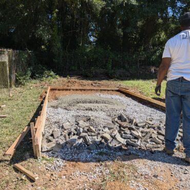 Fresh 3,000 PSI concrete placed on a gravel base inside wood forms for a backyard pad in Austell, Georgia