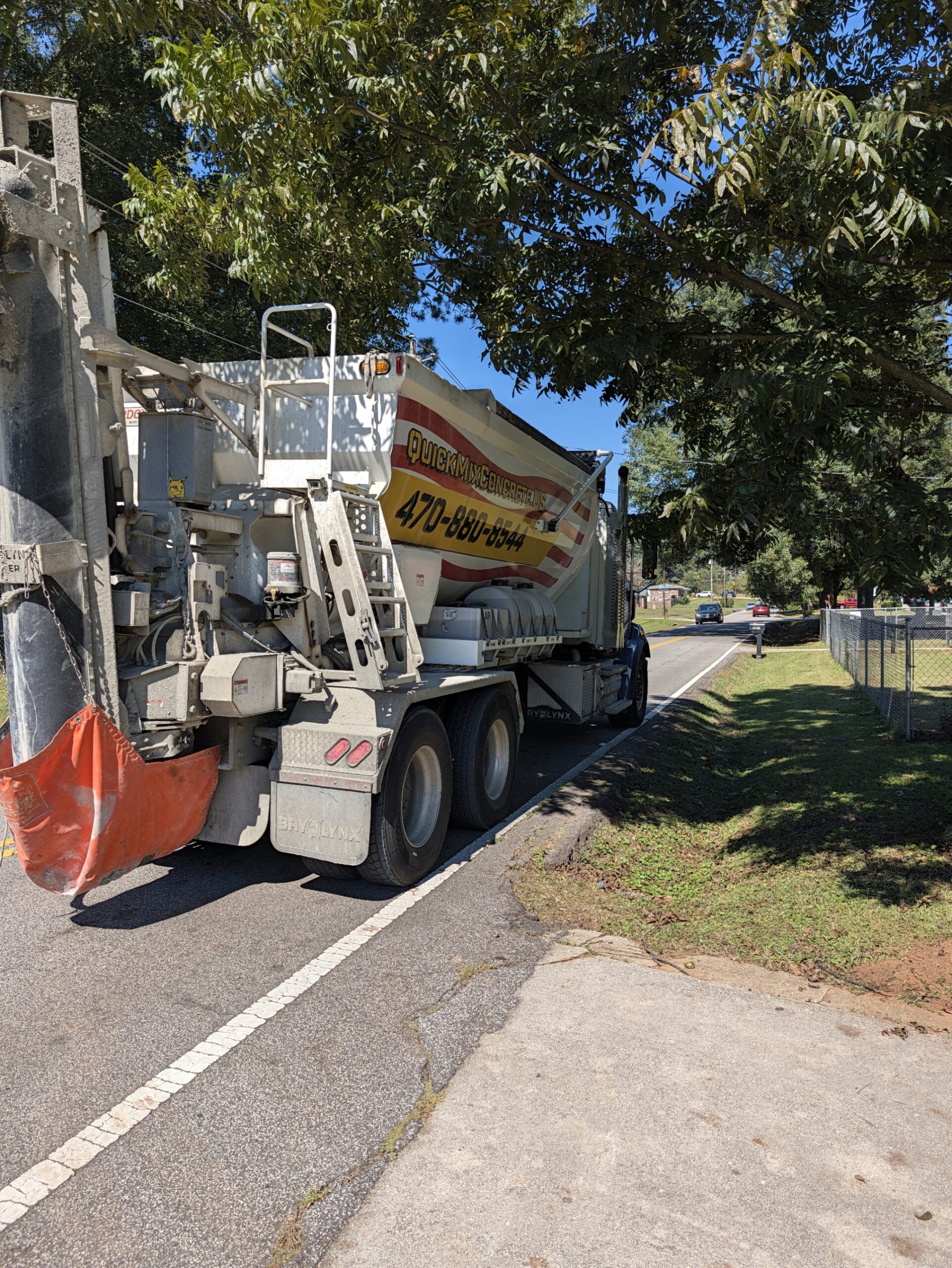 Rear view of a Quick Mix Concrete volumetric mixer truck showing the mixing auger and discharge chute in Austell, Georgia